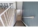 Carpeted staircase with white railing and painted accent wall at 7700 W Glasgow Pl # 11C, Littleton, CO 80128
