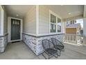 Inviting front porch with stone accents, two chairs, and a view of the home's exterior at 3888 Grand Baker St, Aurora, CO 80019