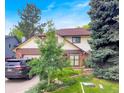 Two-story home with a brick and siding exterior, mature trees, well-maintained lawn and landscaping with a grey car parked in driveway at 7217 S Zephyr Way, Littleton, CO 80128