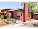 Brick home exterior with well-maintained landscaping and detached garage at 650 Kearney St, Denver, CO 80220