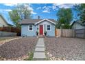 Charming home featuring a well-maintained yard with rock ground cover and a concrete walkway leading to the front door at 134 S Quitman St, Denver, CO 80219