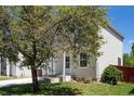 Home exterior features a well-maintained lawn and mature tree on a sunny day, enhancing curb appeal at 1232 Bluebird St, Brighton, CO 80601