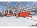 Cozy home with a red exterior and a spacious two-car garage, surrounded by snow at 8754 Snowbird Way, Parker, CO 80134