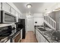 Kitchen with tile floors, white cabinets, granite counters, and black appliances at 4899 S Dudley St # 18A, Littleton, CO 80123