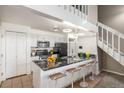 Open kitchen featuring a black countertop island with seating, white cabinets, and modern appliances at 4899 S Dudley St # 18A, Littleton, CO 80123