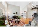 Bright and airy living room with vaulted ceilings, hardwood floors, and a staircase at 85 Willowleaf Dr, Littleton, CO 80127