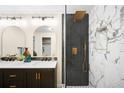 Modern bathroom with double vanity, stylish lighting, and walk-in shower with black and white tile at 6512 Upham St, Arvada, CO 80003