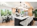 Updated kitchen featuring a large island with white quartz countertops and stylish chandelier lighting at 6512 Upham St, Arvada, CO 80003