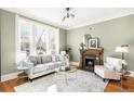 Cozy living room features a fireplace, large window, hardwood floors, and elegant decor at 2823 N Lafayette St, Denver, CO 80205