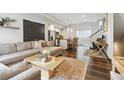 Open-concept living room with hardwood floors, modern furniture and a view of the kitchen and staircase at 1287 Quitman St, Denver, CO 80204