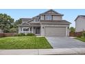 Traditional two-story home boasts a two-car garage and manicured front lawn at 1641 Cedarwood Dr, Longmont, CO 80504