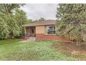 Quaint brick home with mature trees, showcasing a cozy front porch and inviting exterior at 1635 Winona Ct, Denver, CO 80204