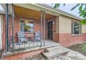 Inviting front porch with seating, showcasing the brick exterior and a welcoming entrance at 1635 Winona Ct, Denver, CO 80204