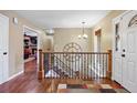 Open foyer with hardwood floors, staircase, large clock and natural light at 7881 S Ivy Ct, Centennial, CO 80112