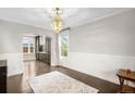 Elegant dining room with hardwood floors, wainscoting, and a stylish chandelier at 8523 S Flower Ct, Littleton, CO 80128