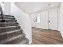 Bright entryway featuring modern vinyl floors and a carpeted staircase leading to the upper level at 45934 Gentry Ave, Bennett, CO 80102