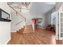 Bright foyer featuring hardwood floors, staircase, chandelier, and large arched window at 13723 Milwaukee Ct, Thornton, CO 80602