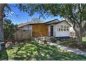 Beautiful single-story home featuring wood paneling, manicured front yard, and an inviting entry at 3469 Benton St, Wheat Ridge, CO 80212