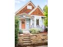 Charming home featuring a quaint front yard with stone retaining wall and colorful, peach-colored front door at 3425 W 34Th Ave, Denver, CO 80211