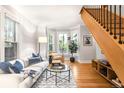 Bright living room featuring hardwood floors, a cozy couch with decor pillows, and large bay windows at 3425 W 34Th Ave, Denver, CO 80211