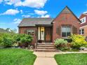 Charming brick home featuring a cozy front porch, well-maintained lawn, and inviting curb appeal under a clear blue sky at 1247 Dexter St, Denver, CO 80220