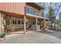 Home's backyard featuring a stone foundation, covered patio and a private hot tub at 266 Lodgepole Dr, Evergreen, CO 80439