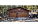 Spacious two-car garage with wood doors and unique antler decor, located near the house at 266 Lodgepole Dr, Evergreen, CO 80439