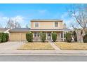 Charming home with a two-car garage, brick facade, trimmed bushes, and a well-manicured front yard at 8610 E Eastman Ave, Denver, CO 80231