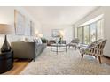 Bright living room with hardwood floors, a cozy rug, modern furniture, and large windows at 8610 E Eastman Ave, Denver, CO 80231