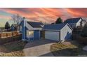 Attractive blue home with a well-manicured lawn, paved driveway and solar panels on roof at 1265 Iris Ct, Highlands Ranch, CO 80126