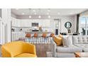 Open-concept kitchen featuring white cabinets, stainless steel appliances, and a large island with seating at 17949 W 94Th Dr, Arvada, CO 80007
