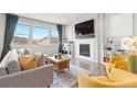 Cozy living room with a fireplace, large windows, and comfortable seating arrangement at 17949 W 94Th Dr, Arvada, CO 80007