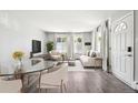 Bright living room with hardwood floors, neutral furniture, and sunlit windows dressed in flowing white drapes at 857 S Van Gordon Ct # B107, Lakewood, CO 80228