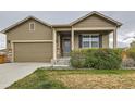 Inviting home exterior with a well-maintained lawn, covered porch, and attached two-car garage at 1888 Ruby Ct, Brighton, CO 80603