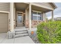 Welcoming front porch with stone accents, a secure Vivint system, and well manicured landscaping at 1888 Ruby Ct, Brighton, CO 80603