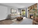 Comfortable living room featuring a stone fireplace, a sofa, and a balcony overlooking the exterior at 4400 S Quebec St # 207L, Denver, CO 80237