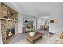 Charming living room with stone fireplace extending into the dining room for an open concept feel at 4400 S Quebec St # 207L, Denver, CO 80237