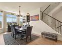 Modern dining room with a hardwood floor, designer rug, and stairway access at 16002 E 111Th Cir, Commerce City, CO 80022