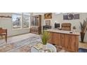 Open living room with a stylish wooden desk, rustic decor, and abundant natural light at 16002 E 111Th Cir, Commerce City, CO 80022