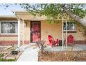 Cozy front porch with red Adirondack chairs and a small table for relaxing and enjoying the outdoors at 2211 Lamar St, Edgewater, CO 80214