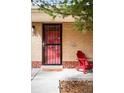 Inviting front porch area showcasing a red Adirondack chair alongside the home's brick facade at 2211 Lamar St, Edgewater, CO 80214