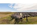 Scenic aerial view of a townhome community situated on a hill with sprawling green spaces and mountain views at 3661 S Perth Cir # 6-101, Aurora, CO 80013
