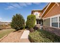 Well-maintained exterior showcasing beautiful landscaping, a walkway, and a combination of stone and green siding at 3661 S Perth Cir # 6-101, Aurora, CO 80013