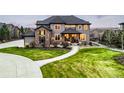 Inviting two-story home featuring a well-maintained lawn and stone accents at 12648 Waterside Ln, Longmont, CO 80504
