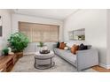 Bright living room with a comfortable couch, stylish ottoman, and large windows at 1454 Jersey St # 104, Denver, CO 80220