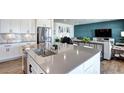 Open-concept kitchen with a stainless steel sink, and granite countertop island, flowing into the living space at 13437 Starhawk Ln, Parker, CO 80134