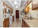 Functional kitchen features wooden cabinets, white appliances, and ample counter space at 7877 E Mississippi Ave # 208, Denver, CO 80247