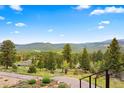 Breathtaking mountain view from a home with lush trees and clear, blue sky at 187 Marion Dr, Evergreen, CO 80439