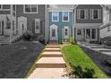 Exterior view of a charming townhome with manicured lawn and walkway leading to the front door at 10567 Dartmouth, Lakewood, CO 80227