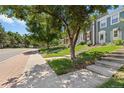 Neighborhood street view with townhouses, mature trees and sidewalks at 10567 W Dartmouth Ave, Lakewood, CO 80227